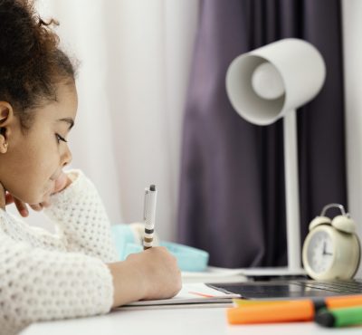 side-view-little-girl-attending-online-school-home-using-laptop